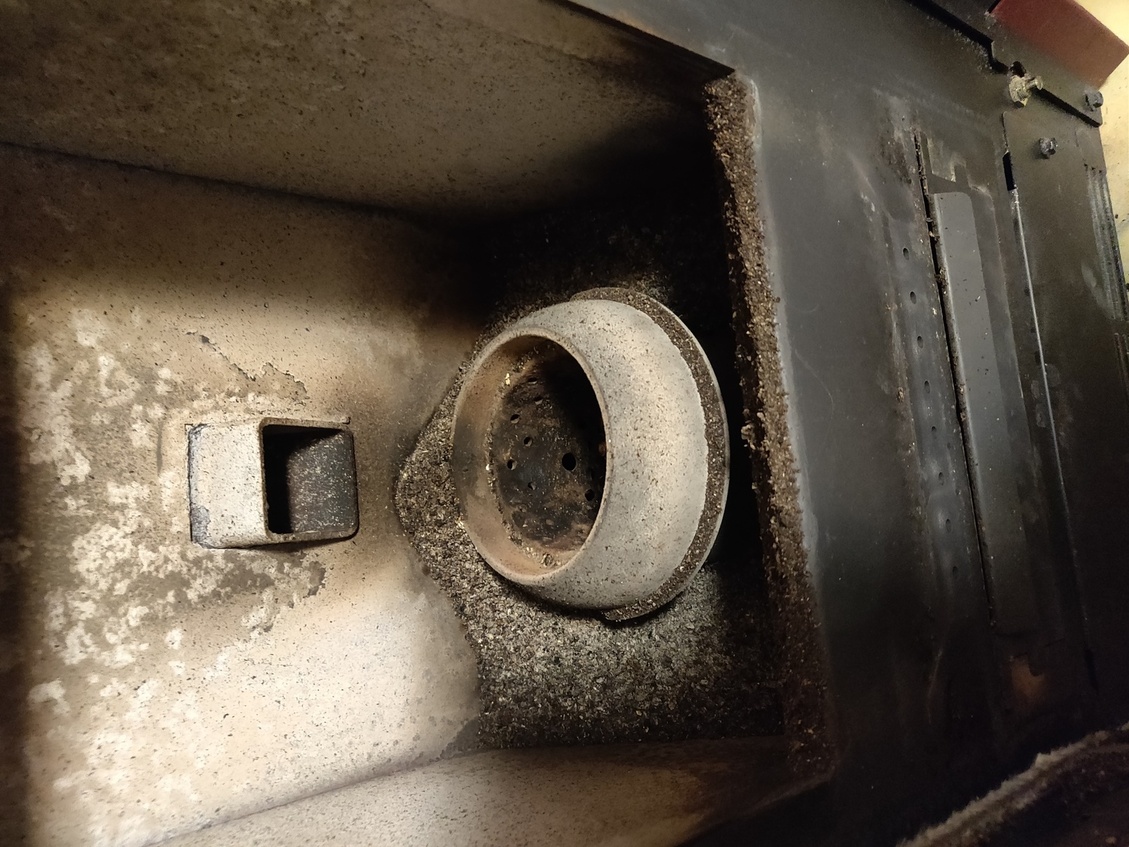 Les cendres dans le creuset du poêle débordent de part et d'autre