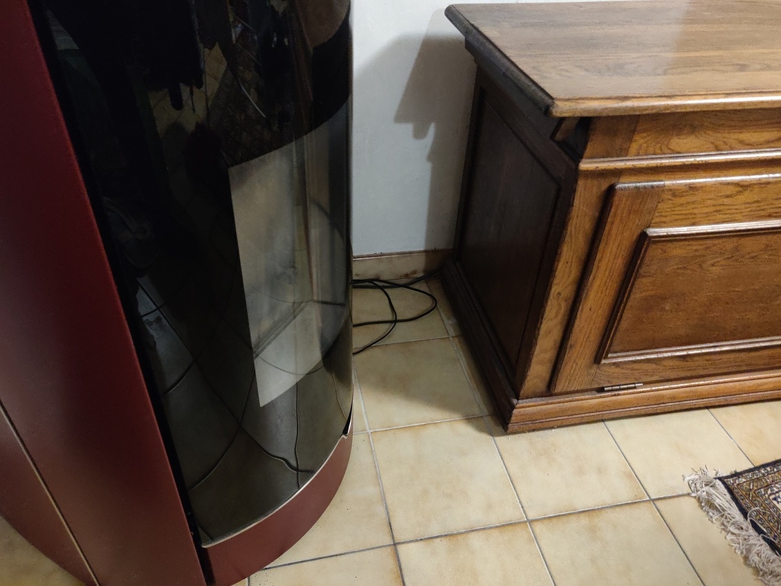 Meuble en bois destiné à contenir l'aspirateur, à coté du poêle