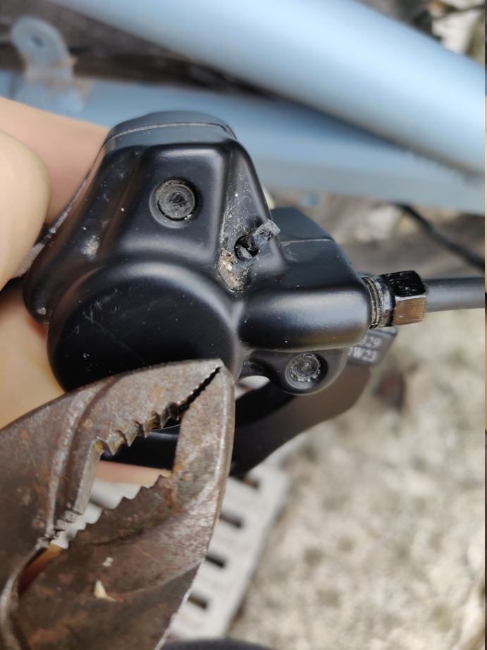 étrier de frein dans lequel on voit le bout de la goupille, une pince est aussi présente pour illustrer le fait qu'il faudra tordre le bout de la goupille afin de l'extraire