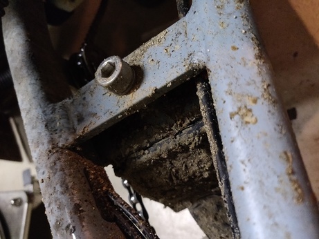 Vue de près de la fixation de la béquille dans les éclats de boue du chemin